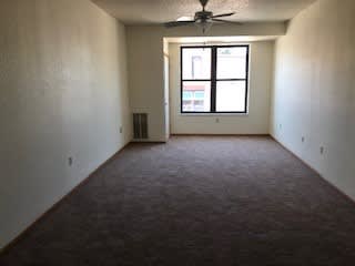 A room with a ceiling fan and a window.