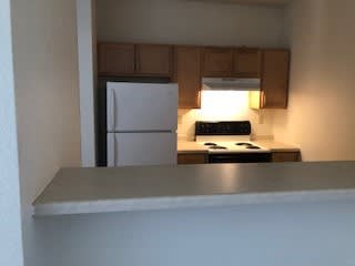 A small kitchen with a white refrigerator and a stove.