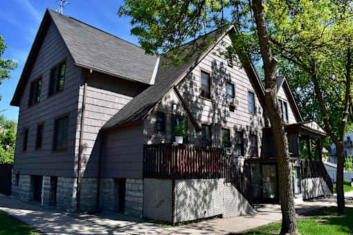A house with a grey facade and a black fence.