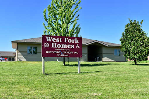A sign for West Fork Homes is in front of a house.