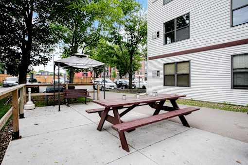 A picnic table is in the middle of a concrete patio.