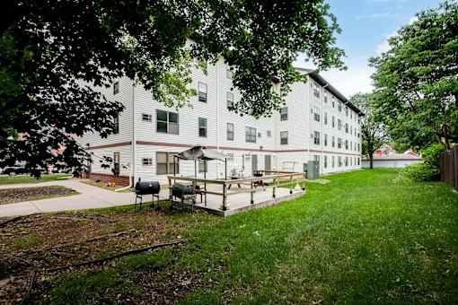A white building with a green lawn in front.