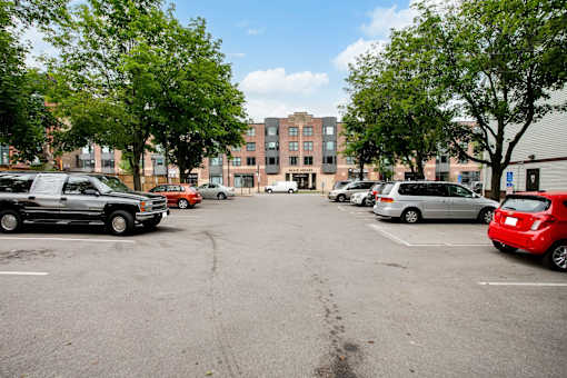 A parking lot with cars and a building in the background.