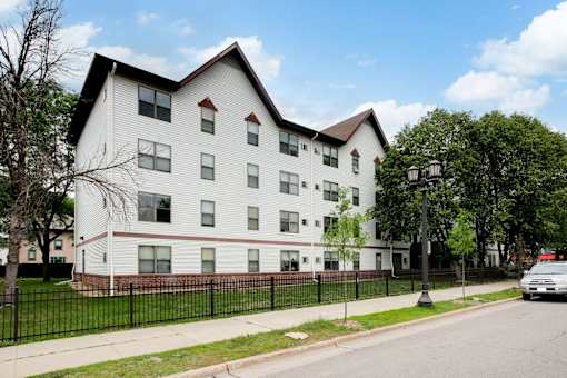 A white building with a black fence in front of it.