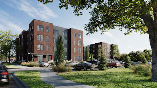A modern apartment complex with a parking lot in front.