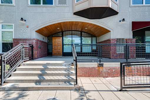 The image shows the front of a building with a red brick wall and a wooden door.