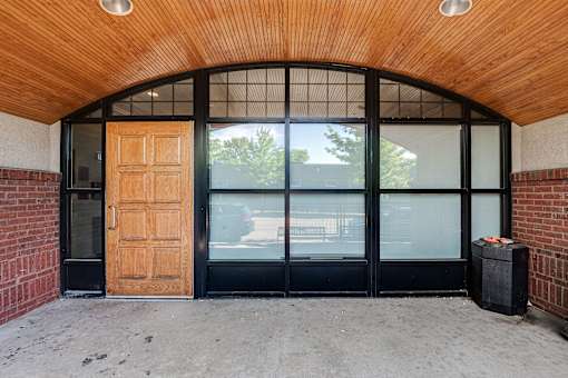 A wooden door is open to a glass window.