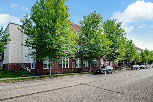 A street view of a residential area with houses and parked cars.
