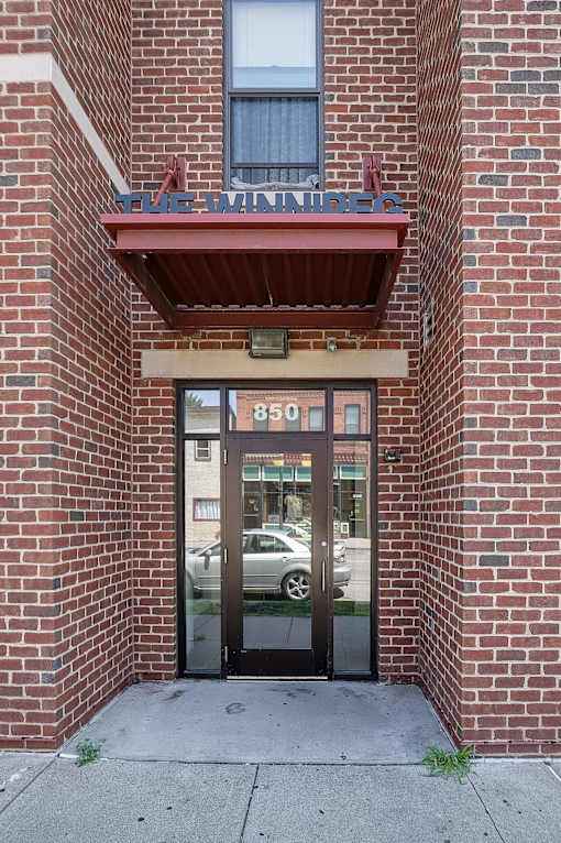 The entrance to a building with a glass door and a sign above it.