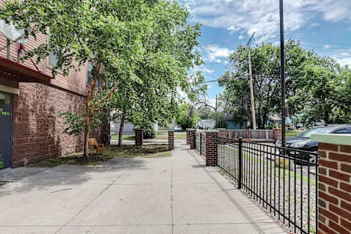 A black metal fence runs along a sidewalk.