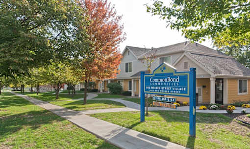 A sign for CommonBond Communities is in front of a house.