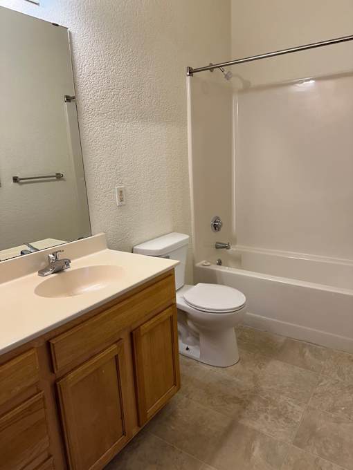 A white toilet sits next to a sink in a bathroom.