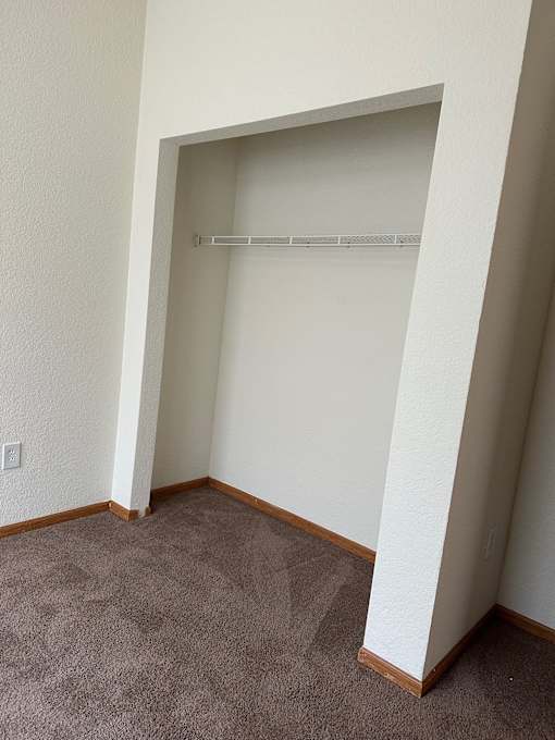 A room with a carpeted floor and a white wall.