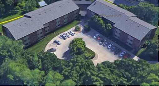 A large building with a parking lot in front of it.