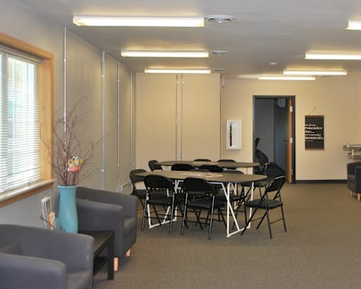A conference room with a table, chairs, and a blue vase.