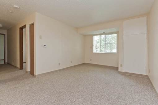 A large, empty room with a window and a door.