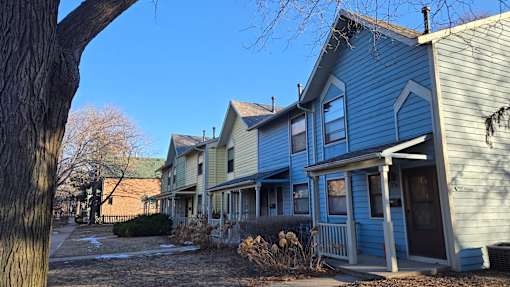 A row of houses with a tree in the foreground.