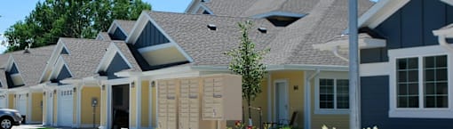 A row of houses with a car parked in front of them.