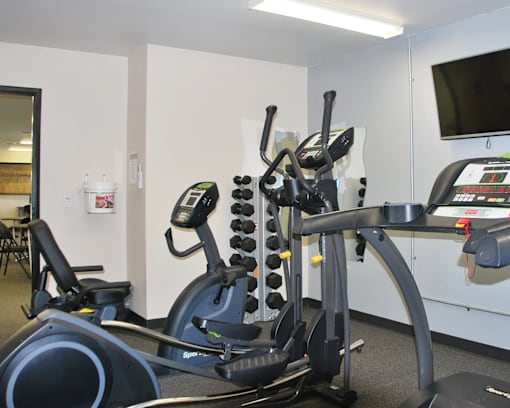 A gym with a stationary bike and a treadmill.