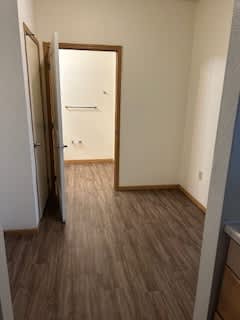 A room with a wooden floor and a white door.