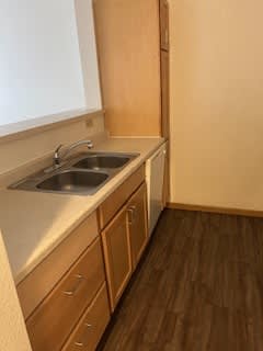 A kitchen with wooden cabinets and a white counter top.