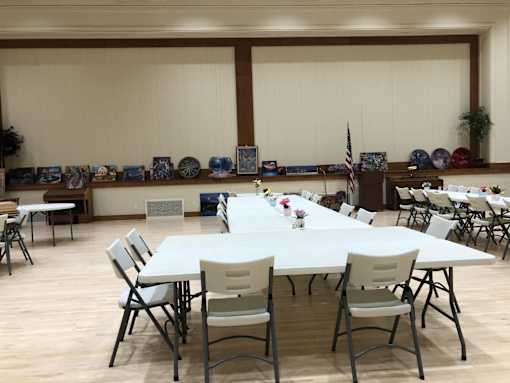 A room with tables and chairs set up for an event.