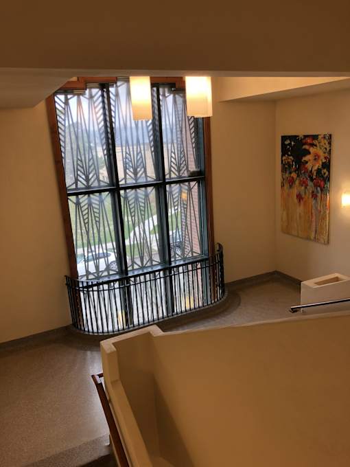 A room with a large window and a painting on the wall.