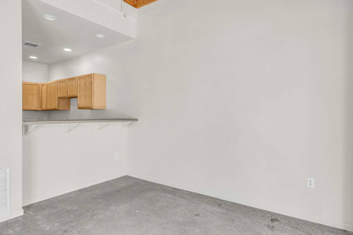 A room with a white wall and a wooden cabinet.