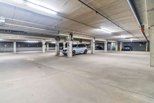 A parking garage with a white car parked in the middle.