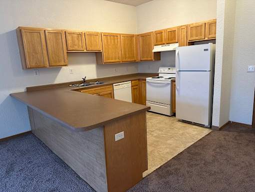 A kitchen with wooden cabinets and a white refrigerator.