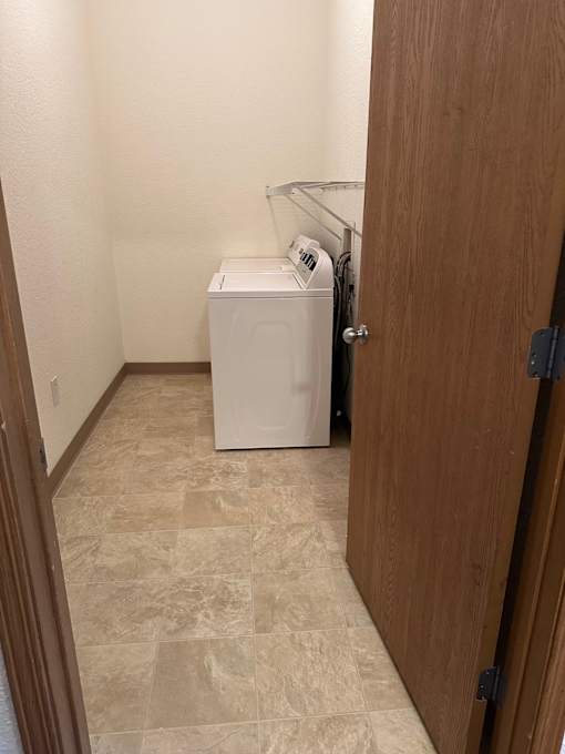 Two front loading washing machines in a kitchen.