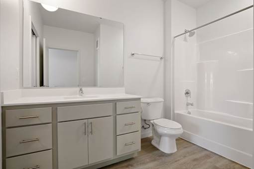 A white bathroom with a sink, toilet, and bathtub.