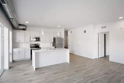 A modern kitchen with white cabinets and a white island.