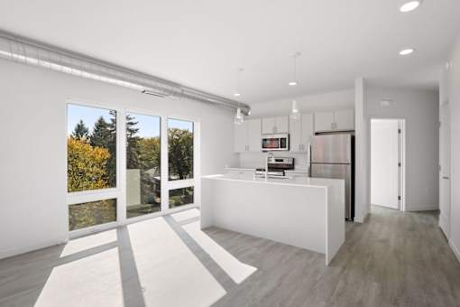 A modern kitchen with a white island and a refrigerator.