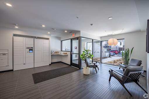 A modern office lobby with a black bench and a brown rug.