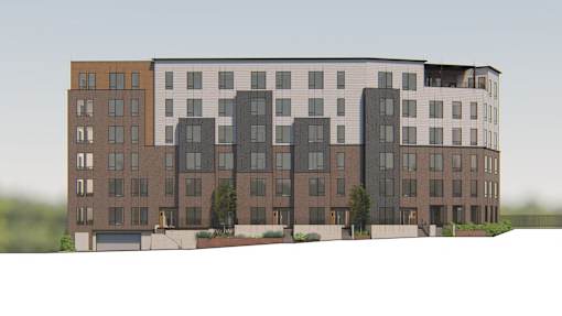 A large, modern apartment building with multiple balconies and a mix of window sizes.