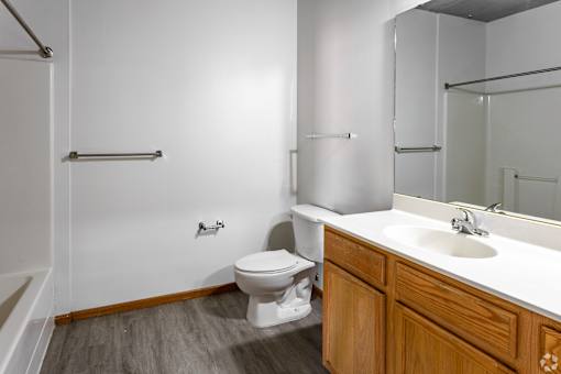 A white toilet sits in a bathroom next to a sink.