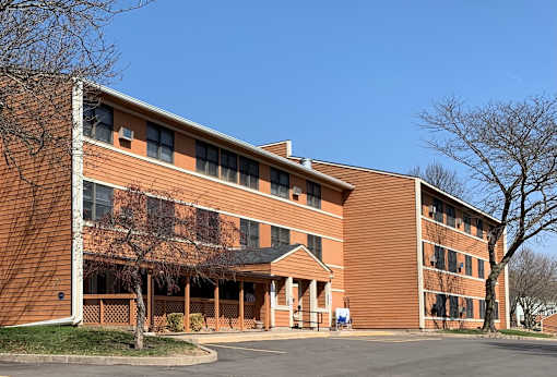 A large red brick building with a tree in front.