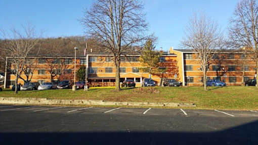 A parking lot in front of a multi-story apartment building.