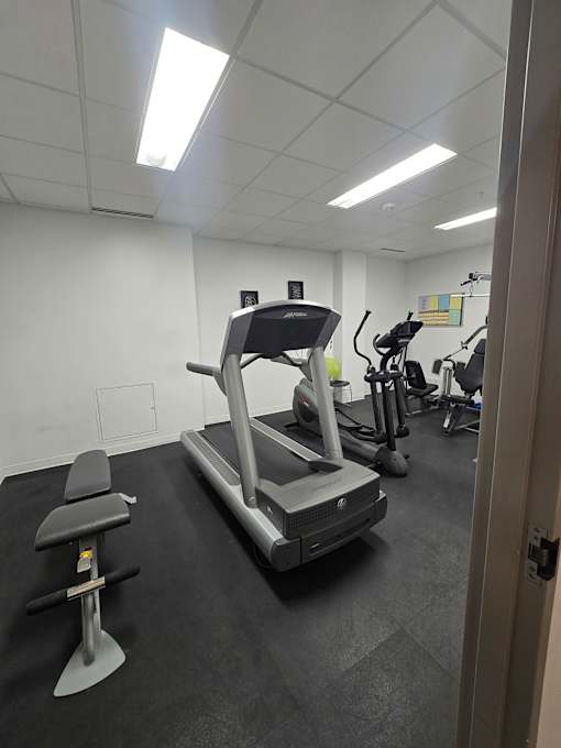 A gym with a treadmill and exercise equipment.