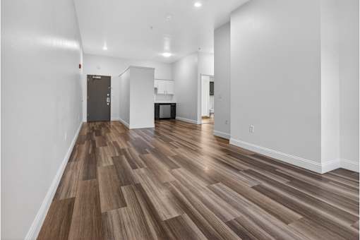 A room with a wood floor and white walls.