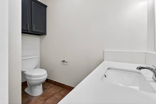 A white toilet sits next to a white sink in a bathroom.