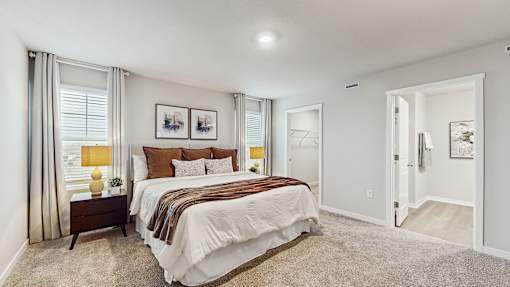A bedroom with a large bed and a painting on the wall.
