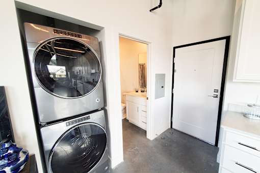 Stackable in-unit washer and dryer located in a laundry closet next to a bathroom.