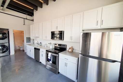 A kitchen with stainless steel appliances and white cabinets.