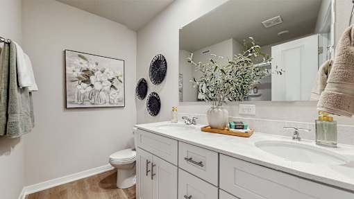 A bathroom with a toilet, sink, and a mirror.