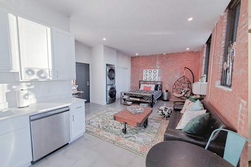 A kitchen with a refrigerator, oven, and sink.