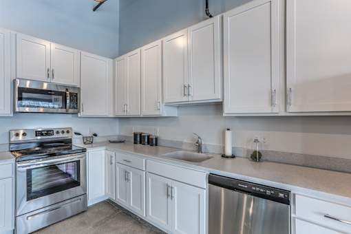 A kitchen with white cabinets and stainless steel appliances.