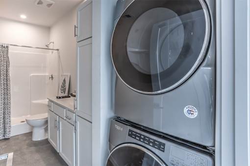 A modern laundry room with a washing machine and dryer.