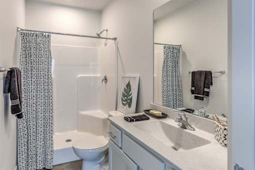 A bathroom with a toilet, sink, and shower curtain.